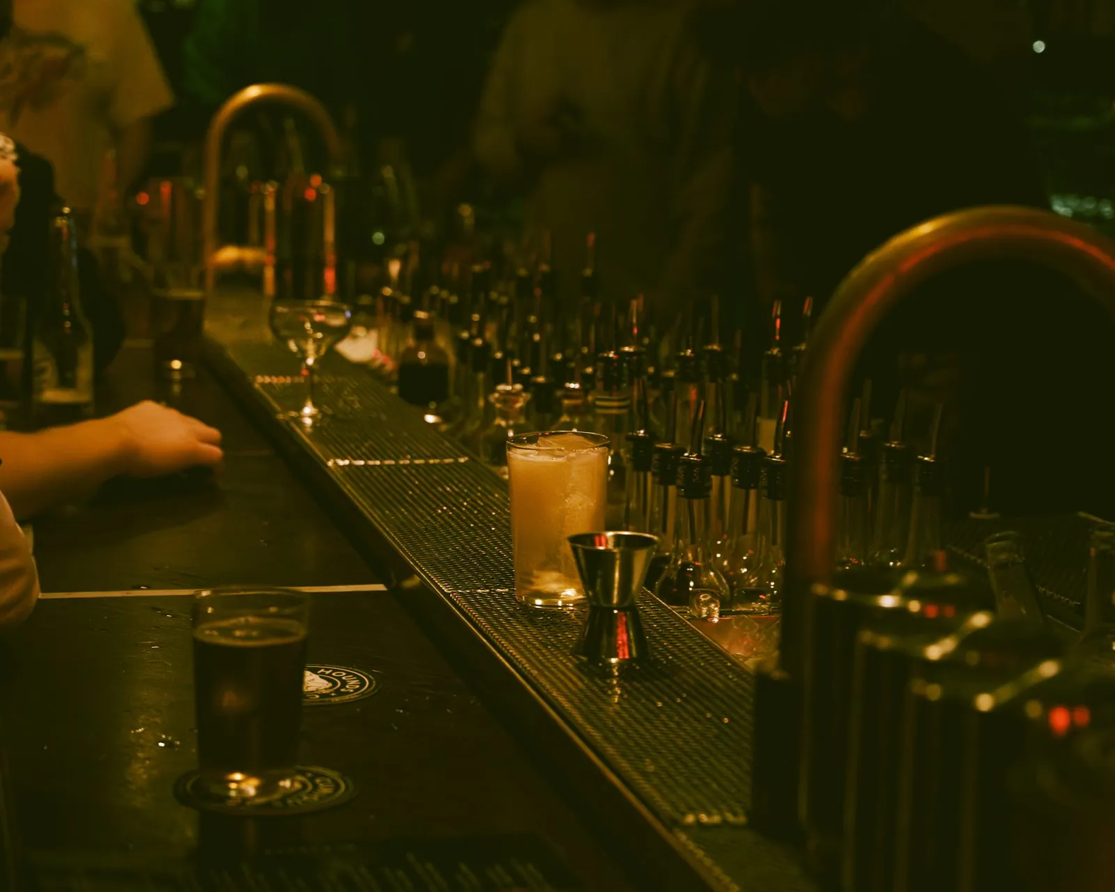 The back bar, dim, a drink waiting