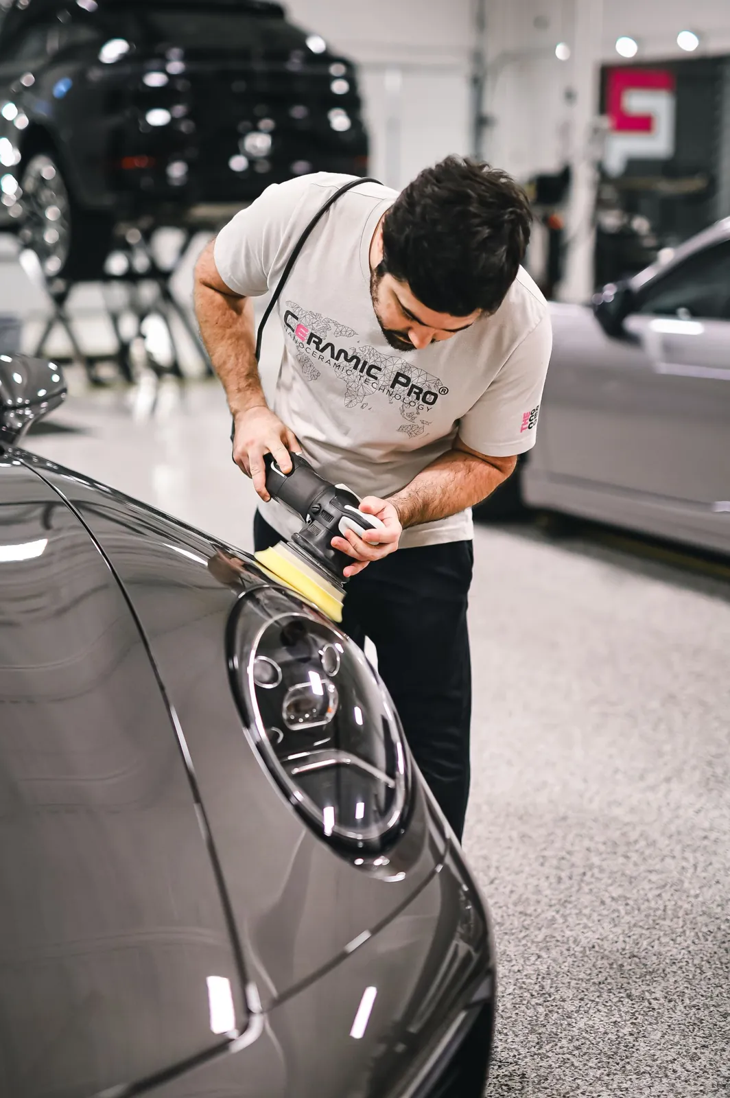 Machine-polishing a bonnet under shop lights